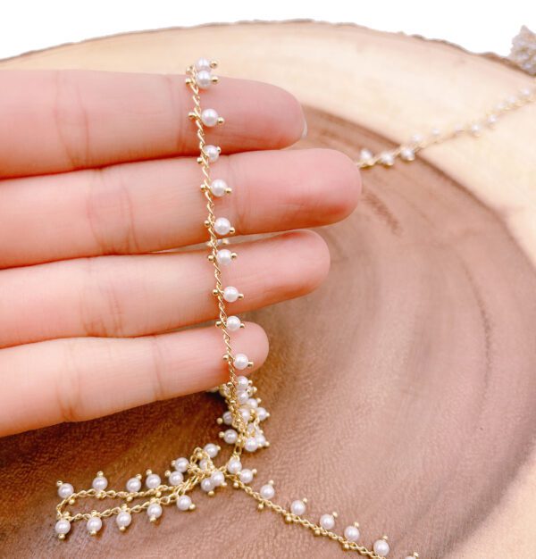 Hand holding pearl beaded chain